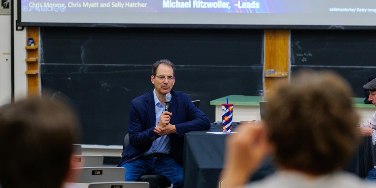 Attorney General Phil Weiser speaking to a room of students